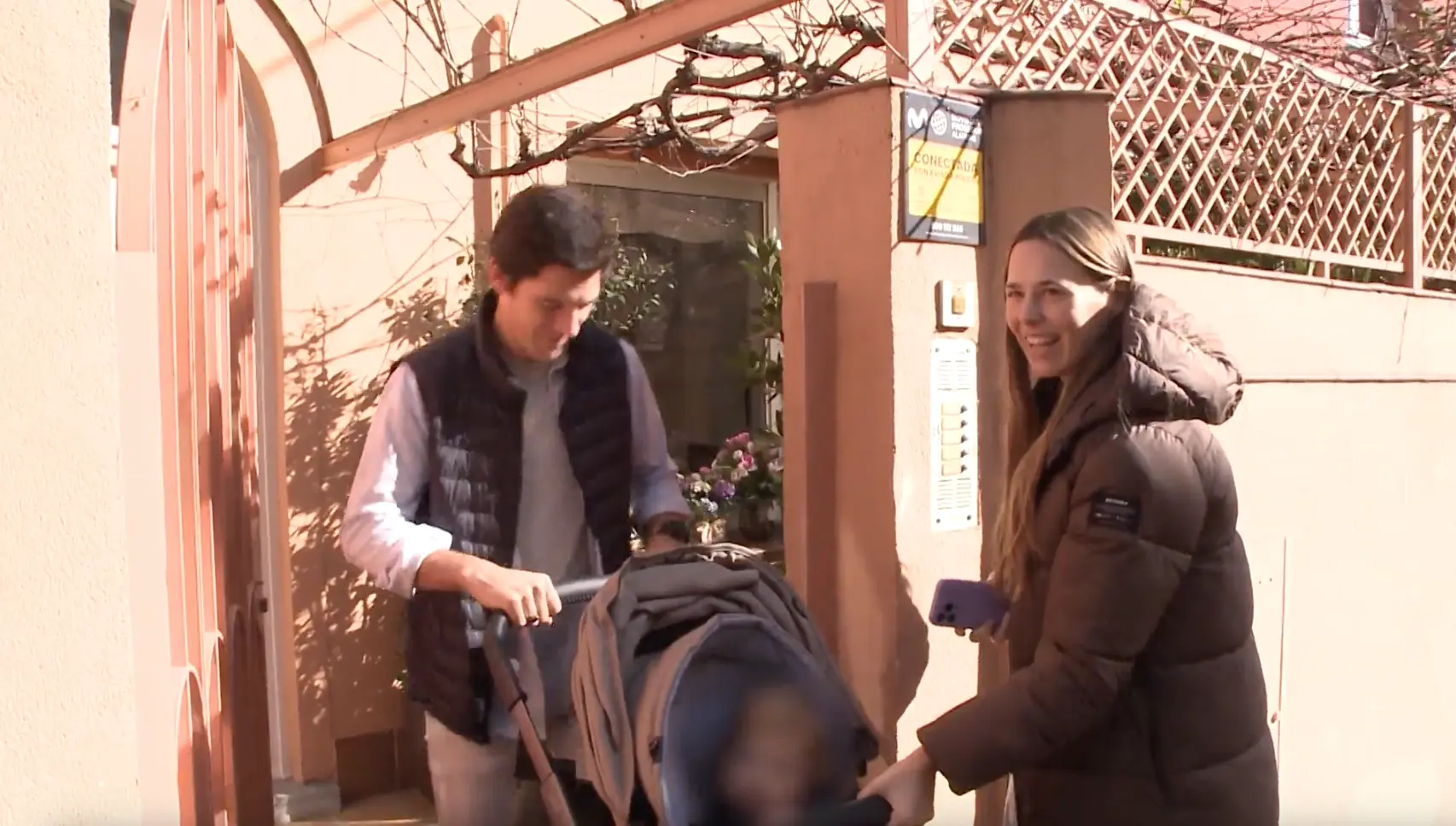 Claudia Osborne y José Entrecanales entrando en casa con su hija Micaela en carrito