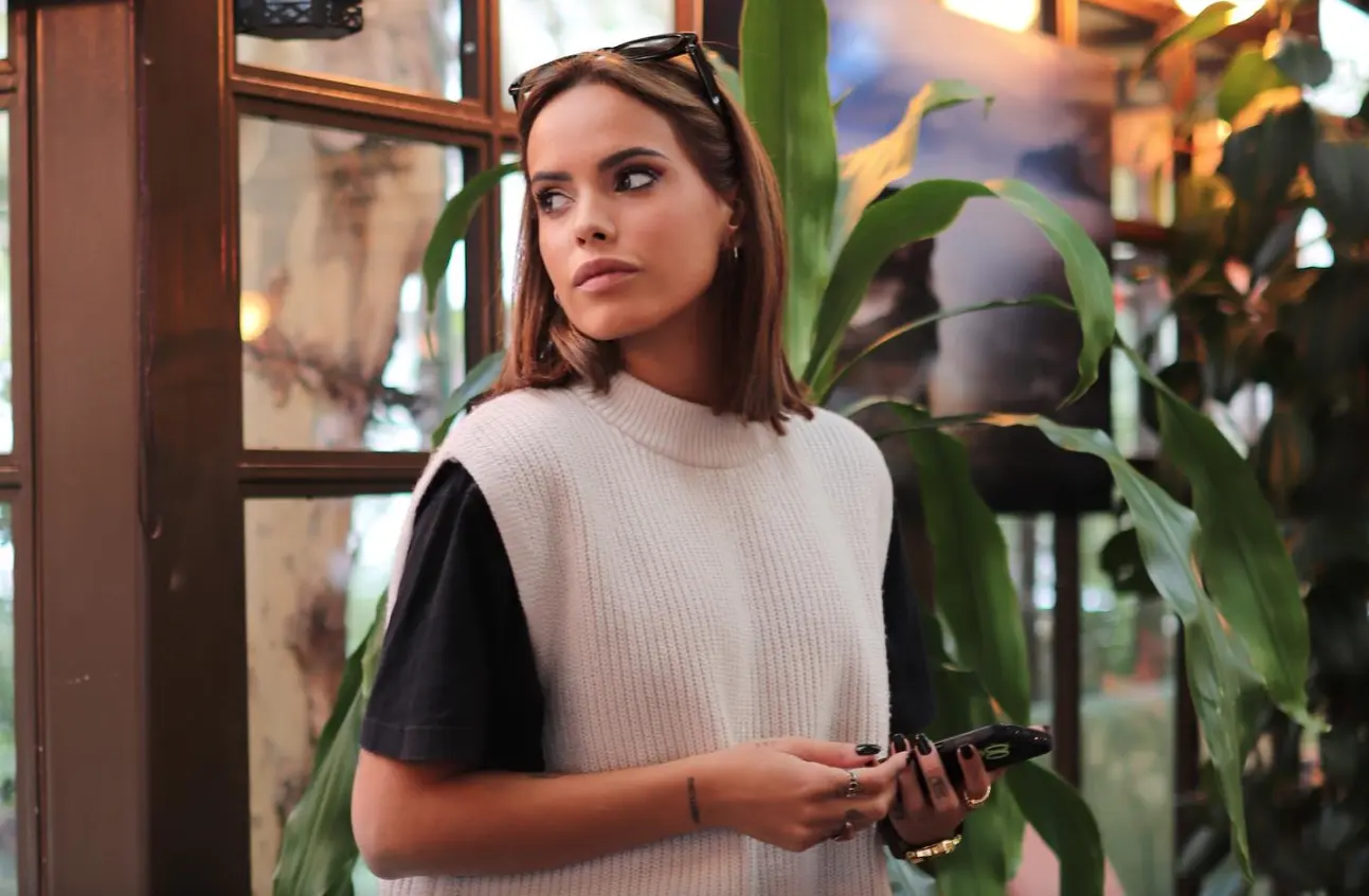 Gloria Camila posando seria en una cafetería.