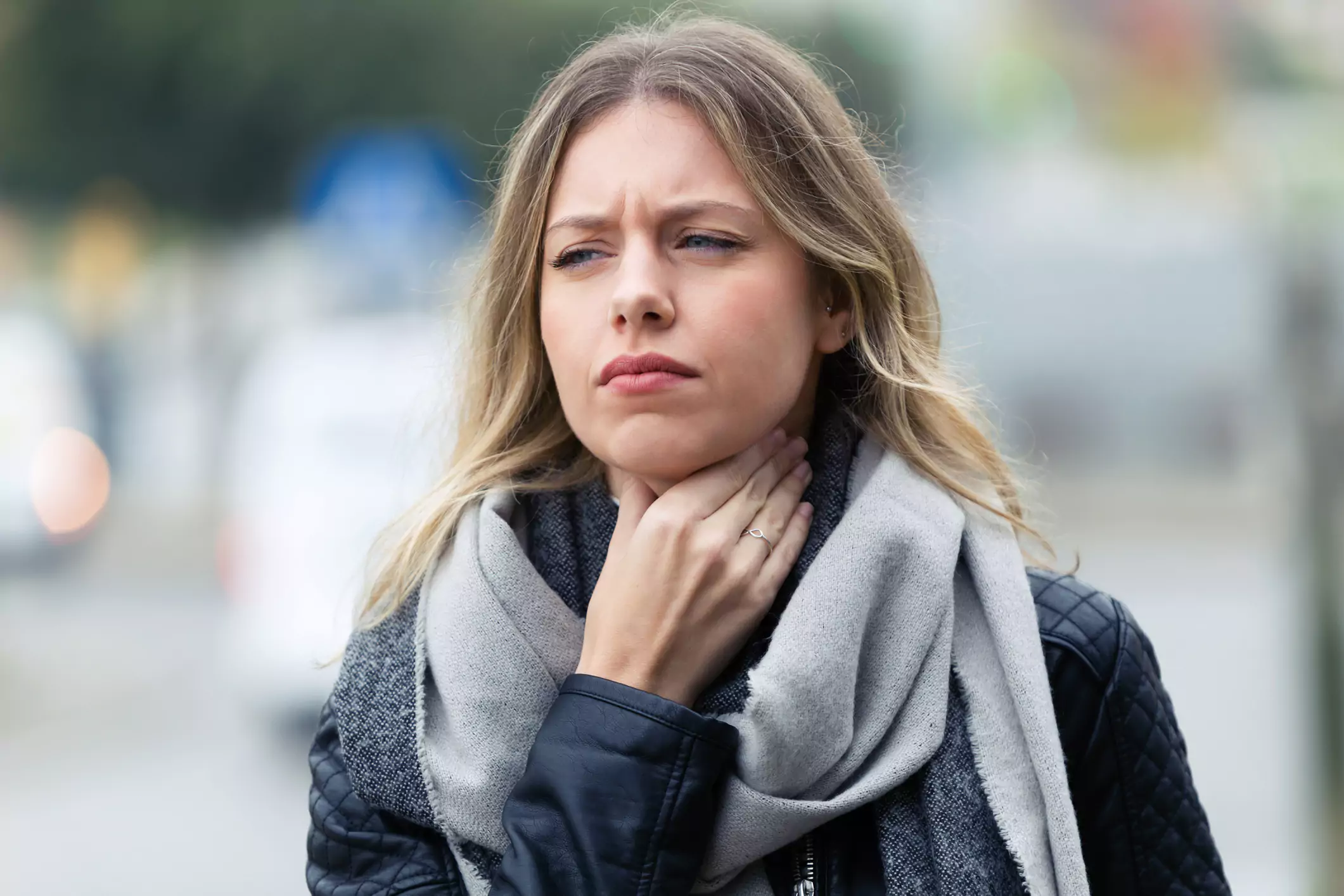Mujer joven resfriada con dolor de garganta