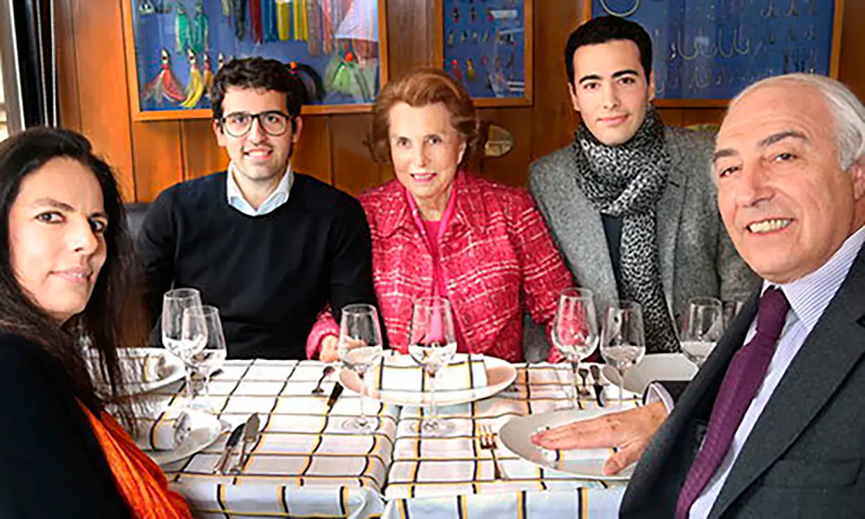Liliane Bettencourt, sentada entre sus dos nietos, Jean-Victor (izquierda) y Nicolas, en una comida familiar cuando la rela