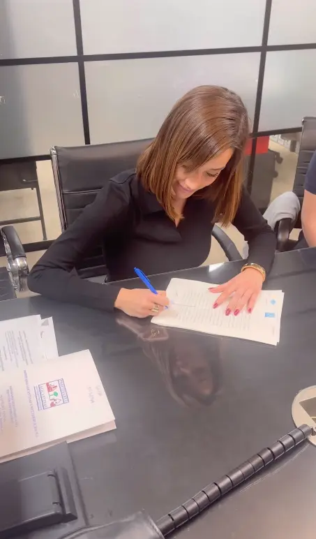 Adara Molinero firmando la compra de sus pisos.