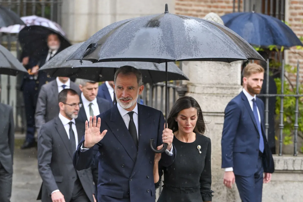 Felipe y Letizia bajo un paraguas negro.