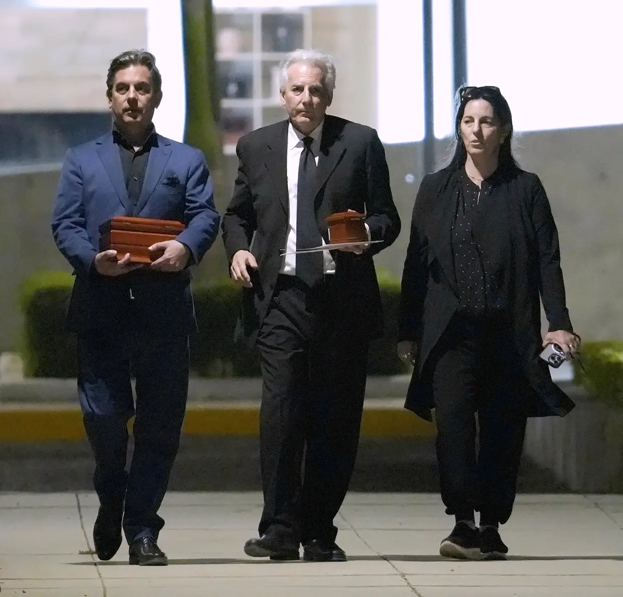 Los tres hijos de Mario Vargas Llosa, Gonzalo, Álvaro y Morgana, llevando las cenizas de su padre.
