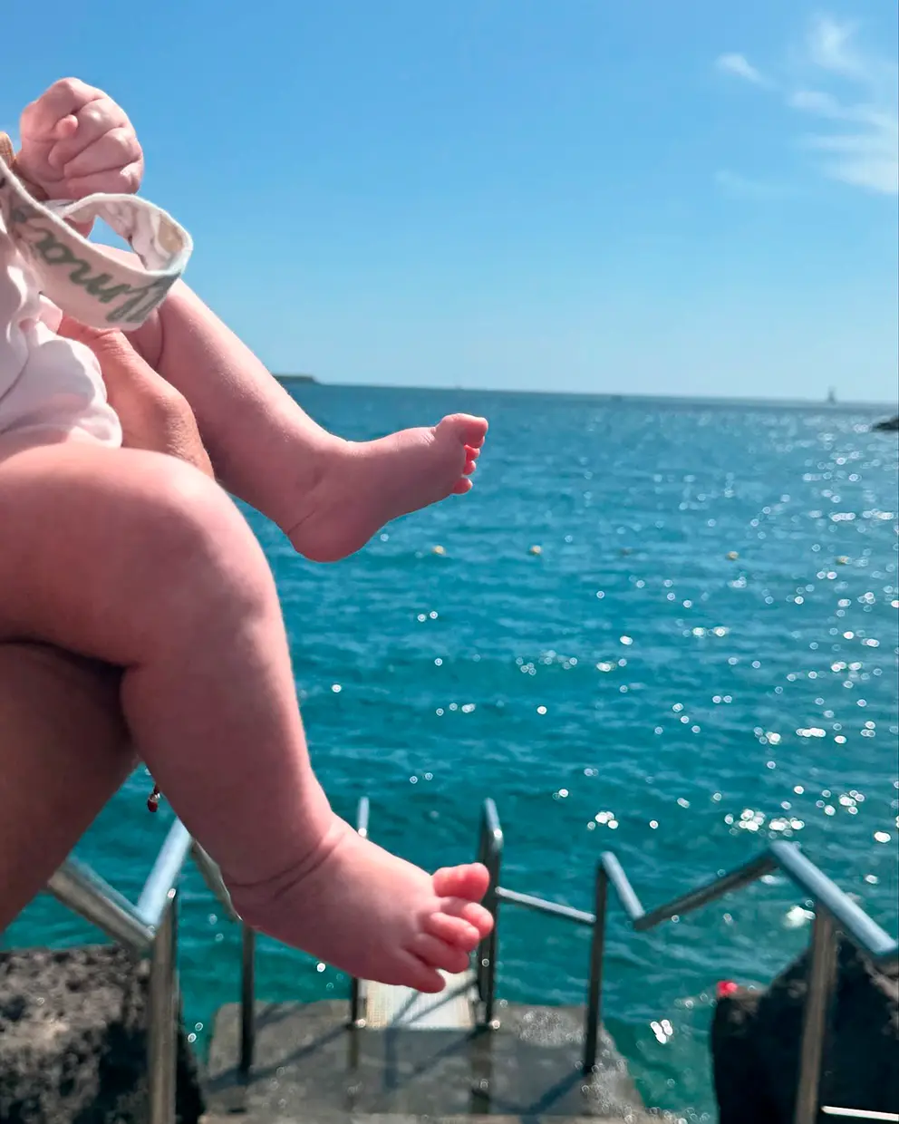 Las pequeñas piernas de Alma, la hija de Anabel Pantoja, junto al mar.