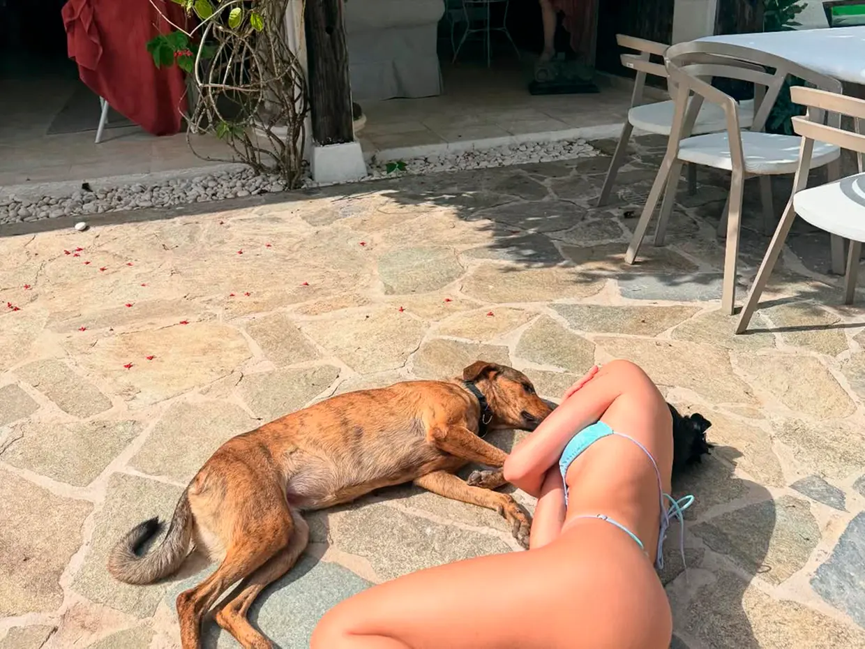 Aitana tumbada en el suelo junto a un perro