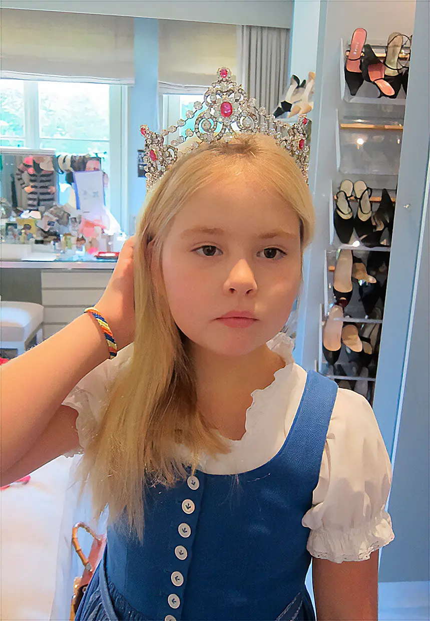 Amalia de Holanda probándose una tiara cuando era una niña.