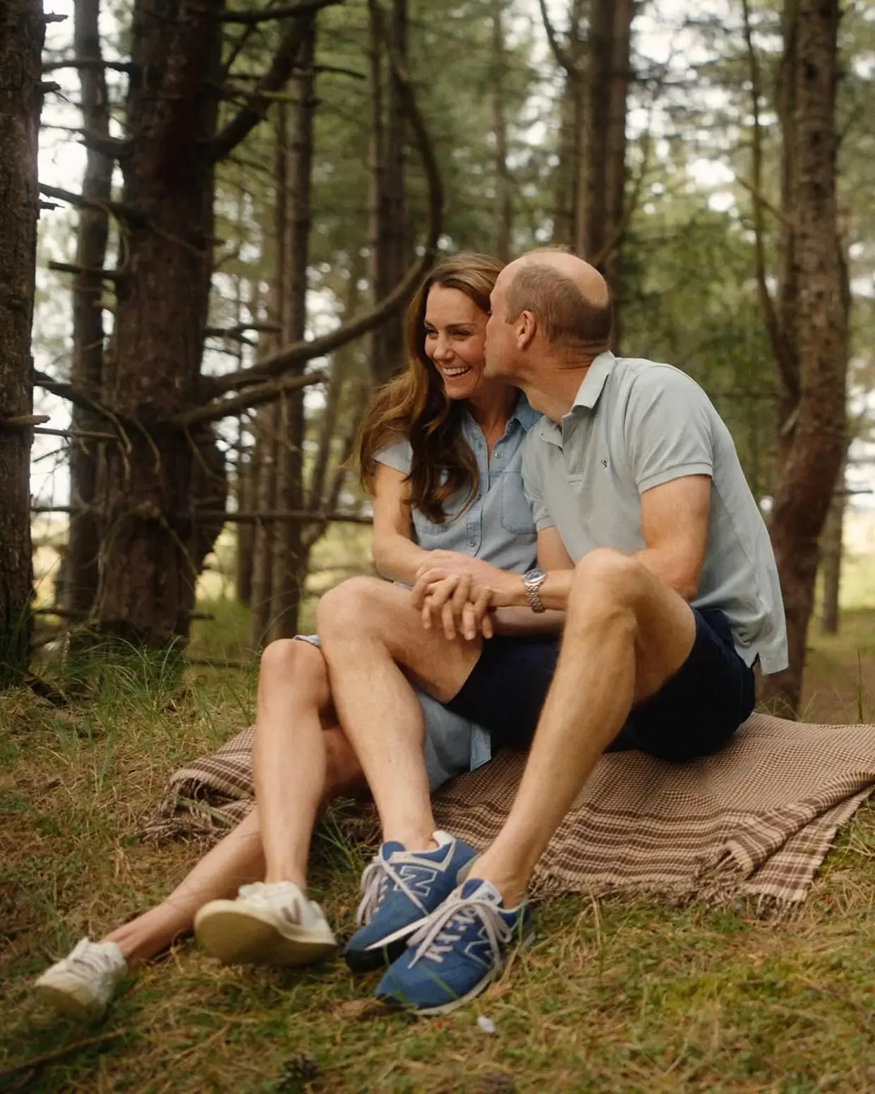 Kate Middleton sonriente y besada en la mejilla por el príncipe Guillermo.