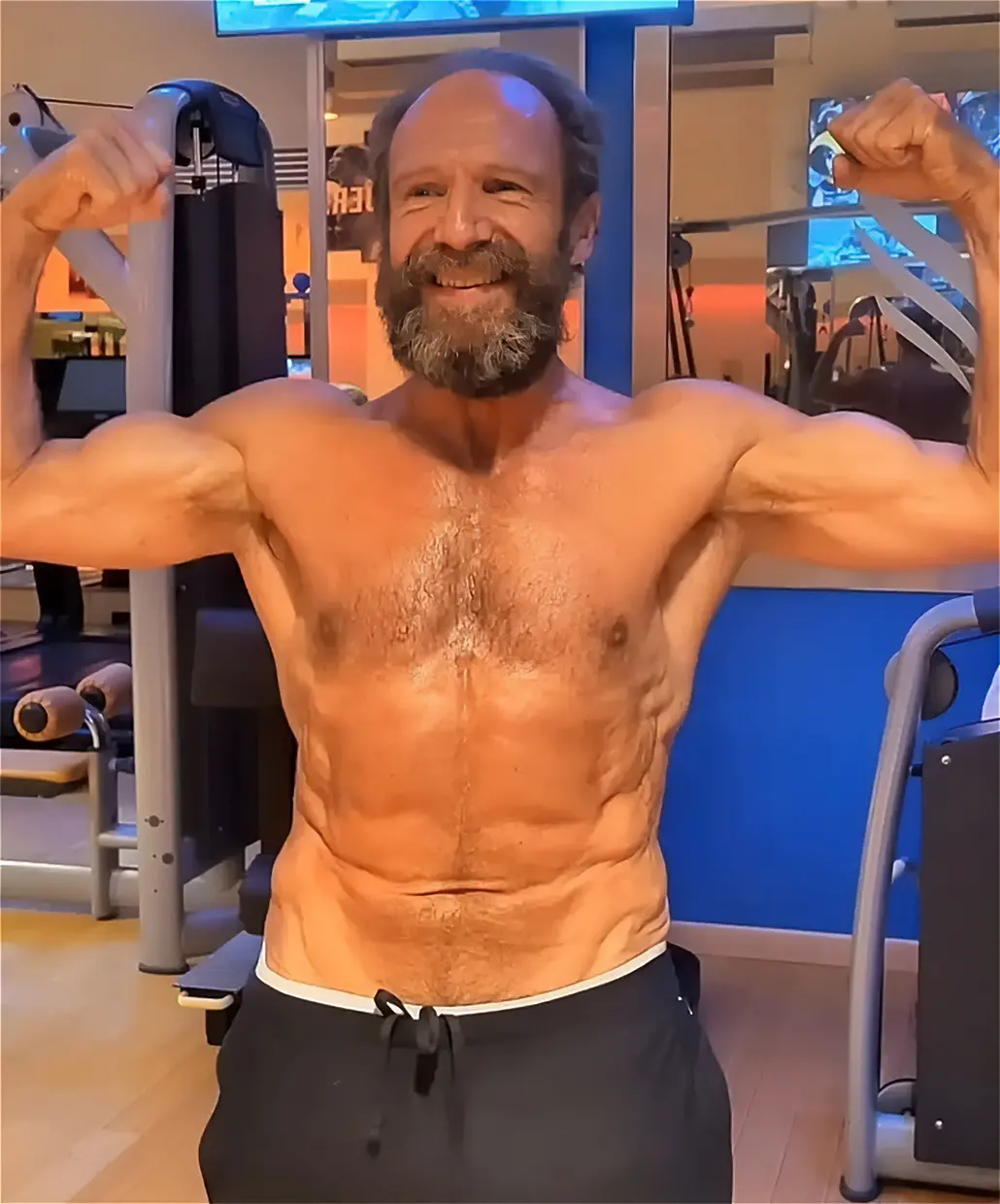 Ralph Fiennes mostrando su torso en un gimnasio