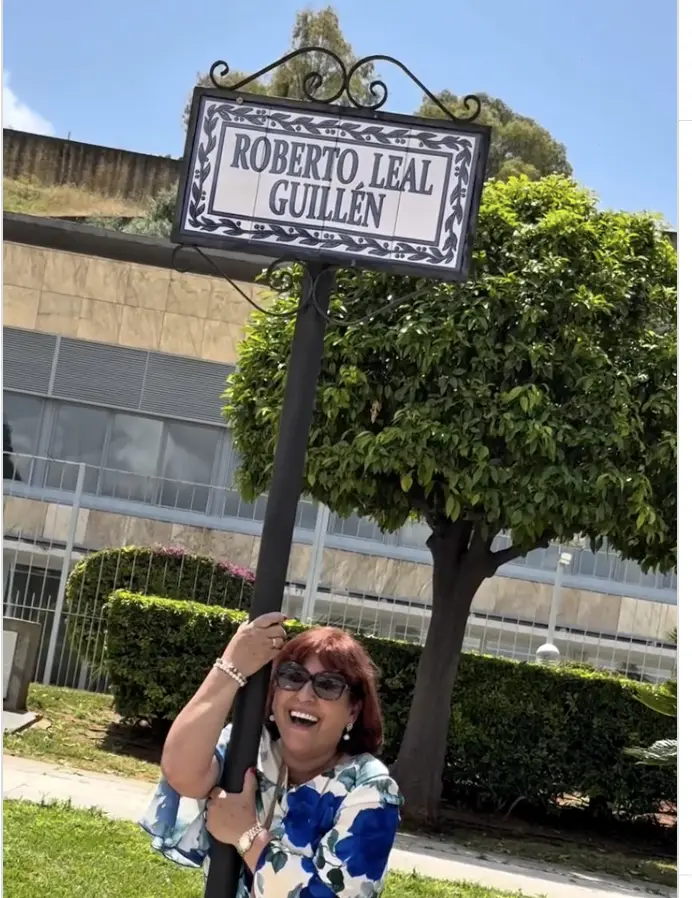 Mercedes Guillén agarrada al cartel de la calle que incluye su apellido.