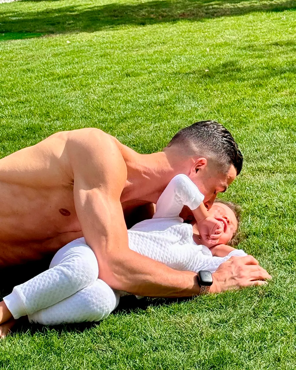Cristiano Ronaldo besando a su hija Bella Esmeralda en su jardín.