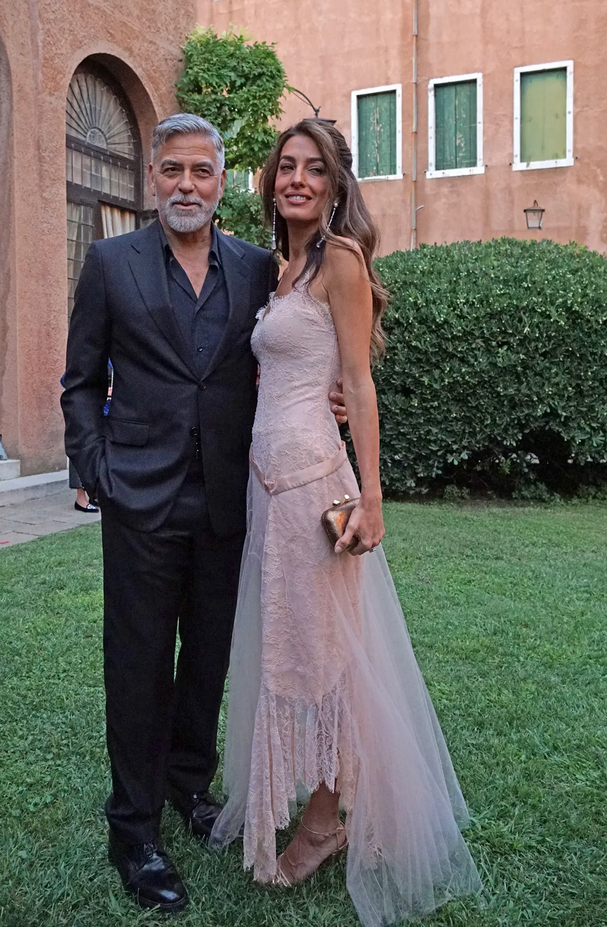 Amal Clooney George Clooney hoy posando juntos en un jardín.