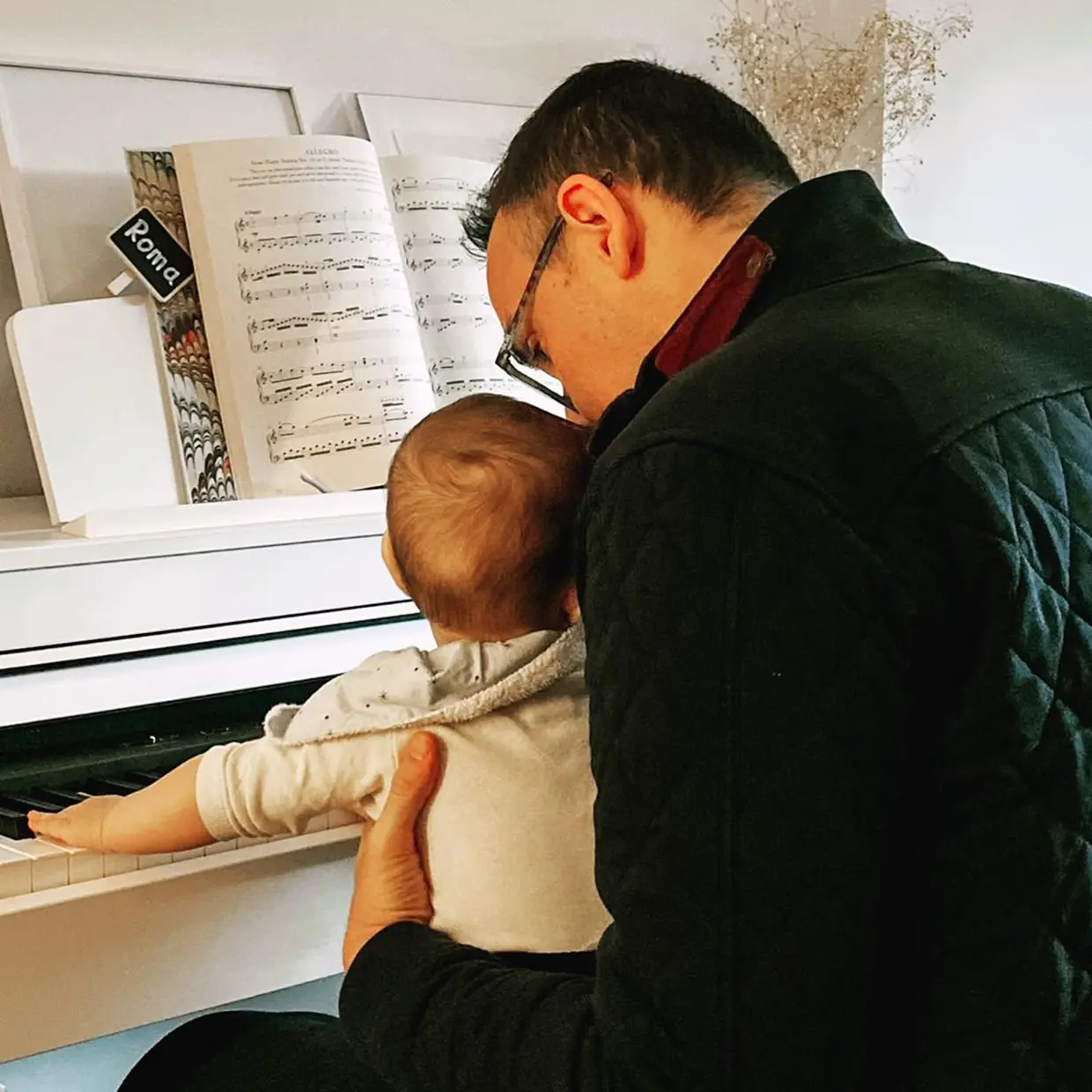 Risto Mejide con su hija Roma en brazos delante de un piano.