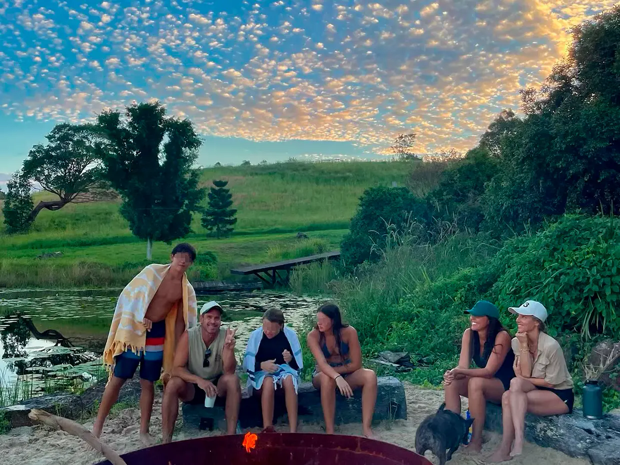 Elsa Pataky con sus amigos y familia alrededor de una hoguera durante una puesta de sol.
