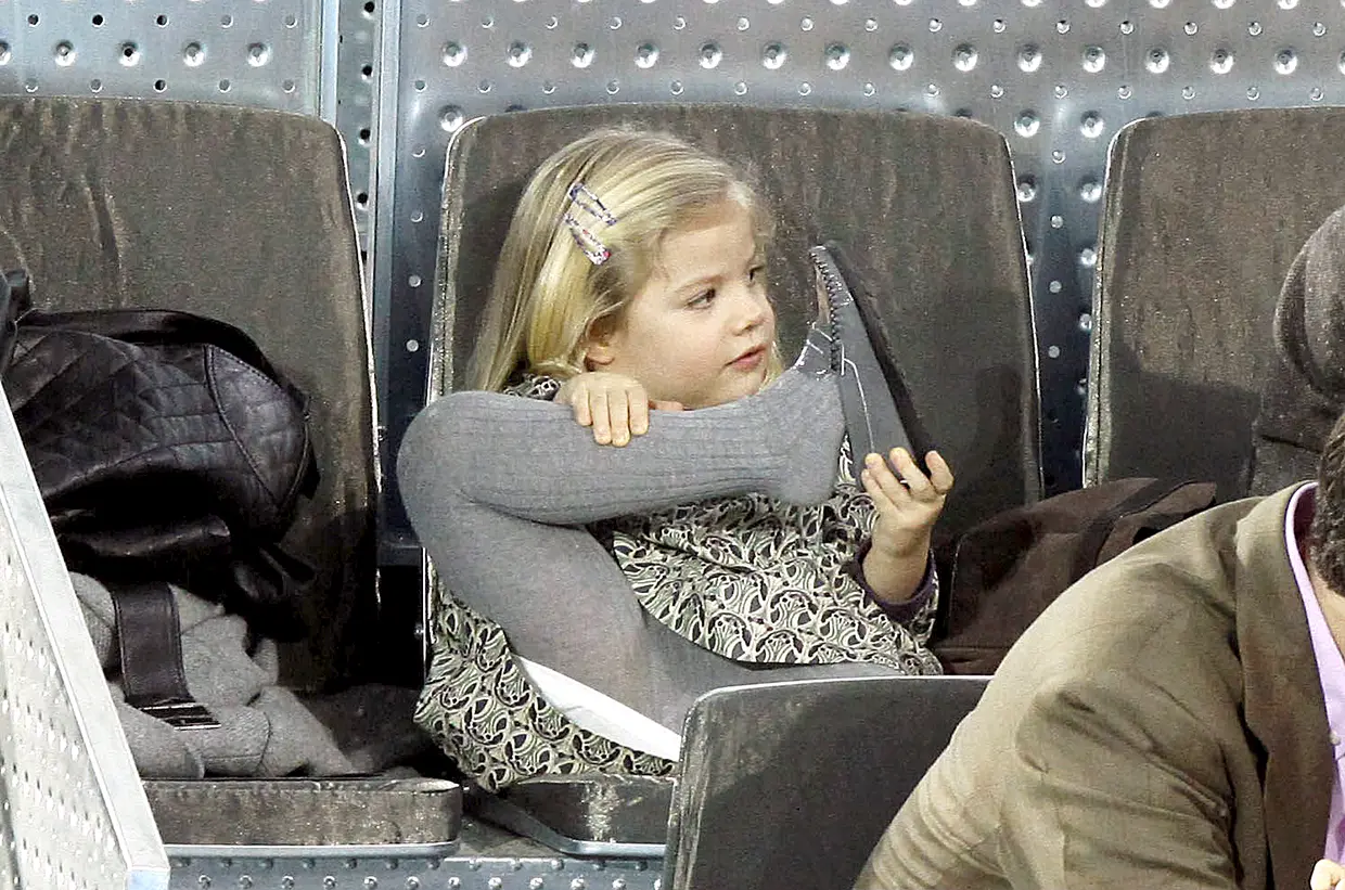 Infanta Sofía de niña jugando con su pierna durante un partido de tenis.