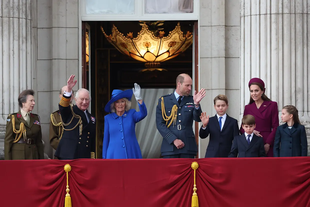 La familia real inglesa saludando desde el valcón de su palacio.