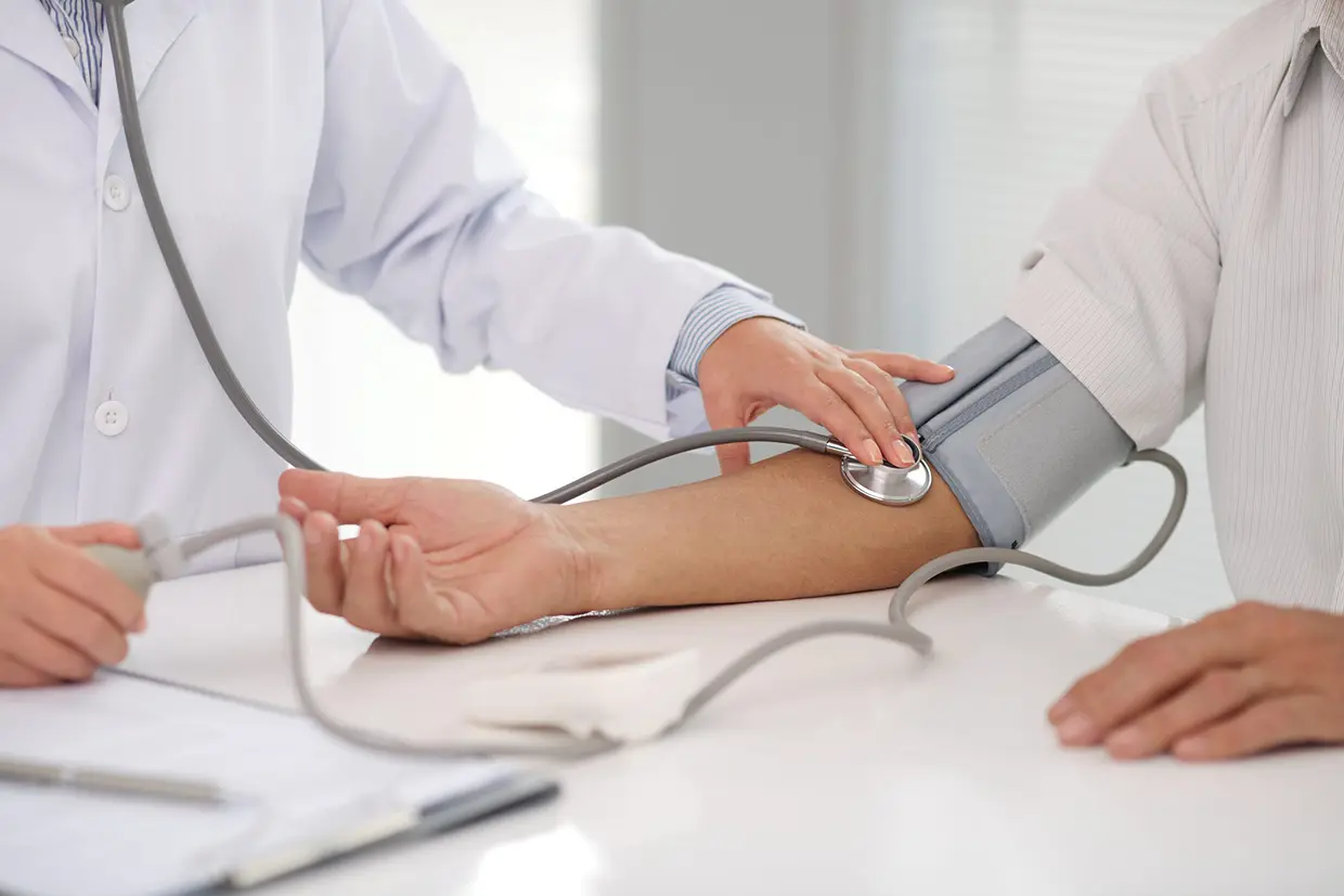 Doctor midiendo la tensión arterial a un paciente