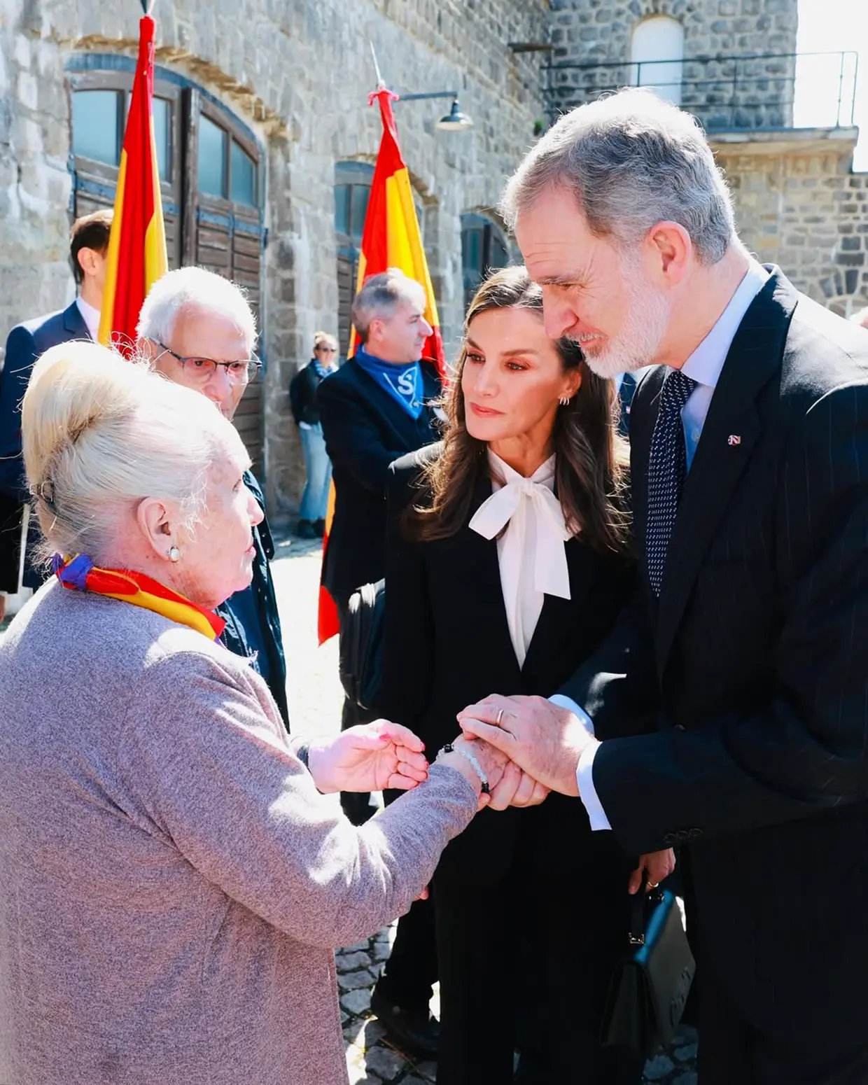 Felipe VI y la reina Letizia saludando a una señora en Mauthausen