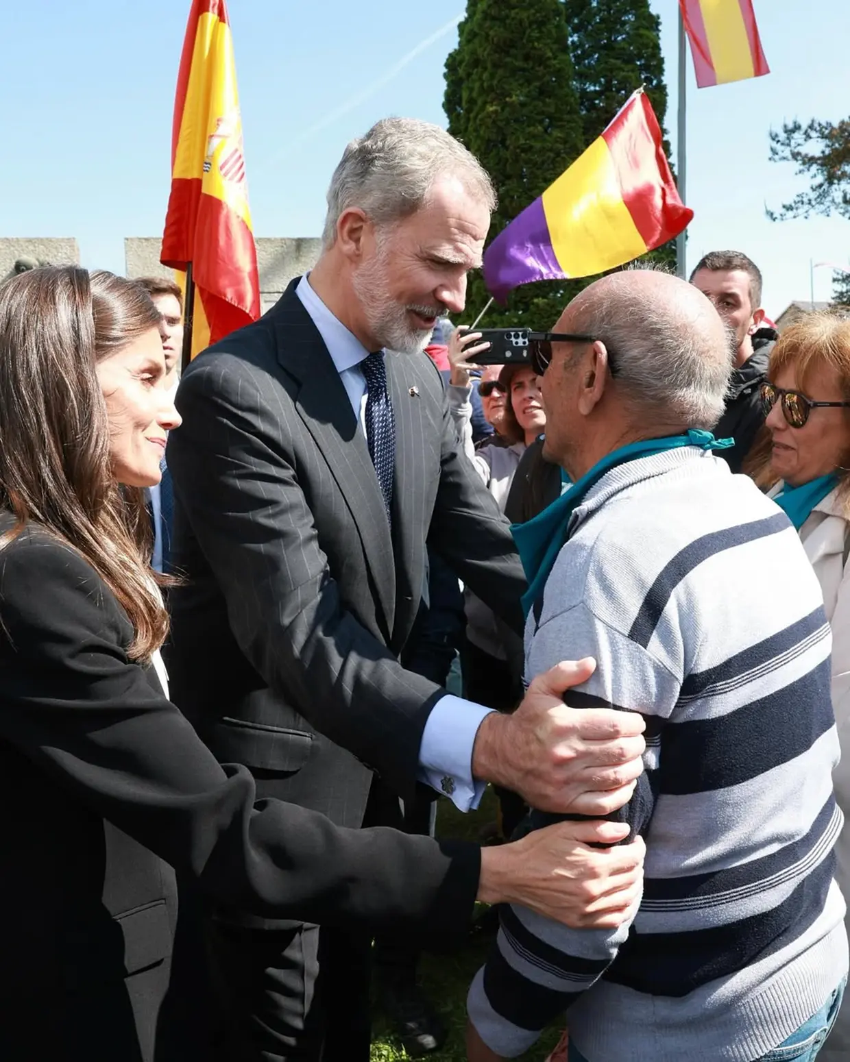 Felipe VI y Letizia hablando con un señor