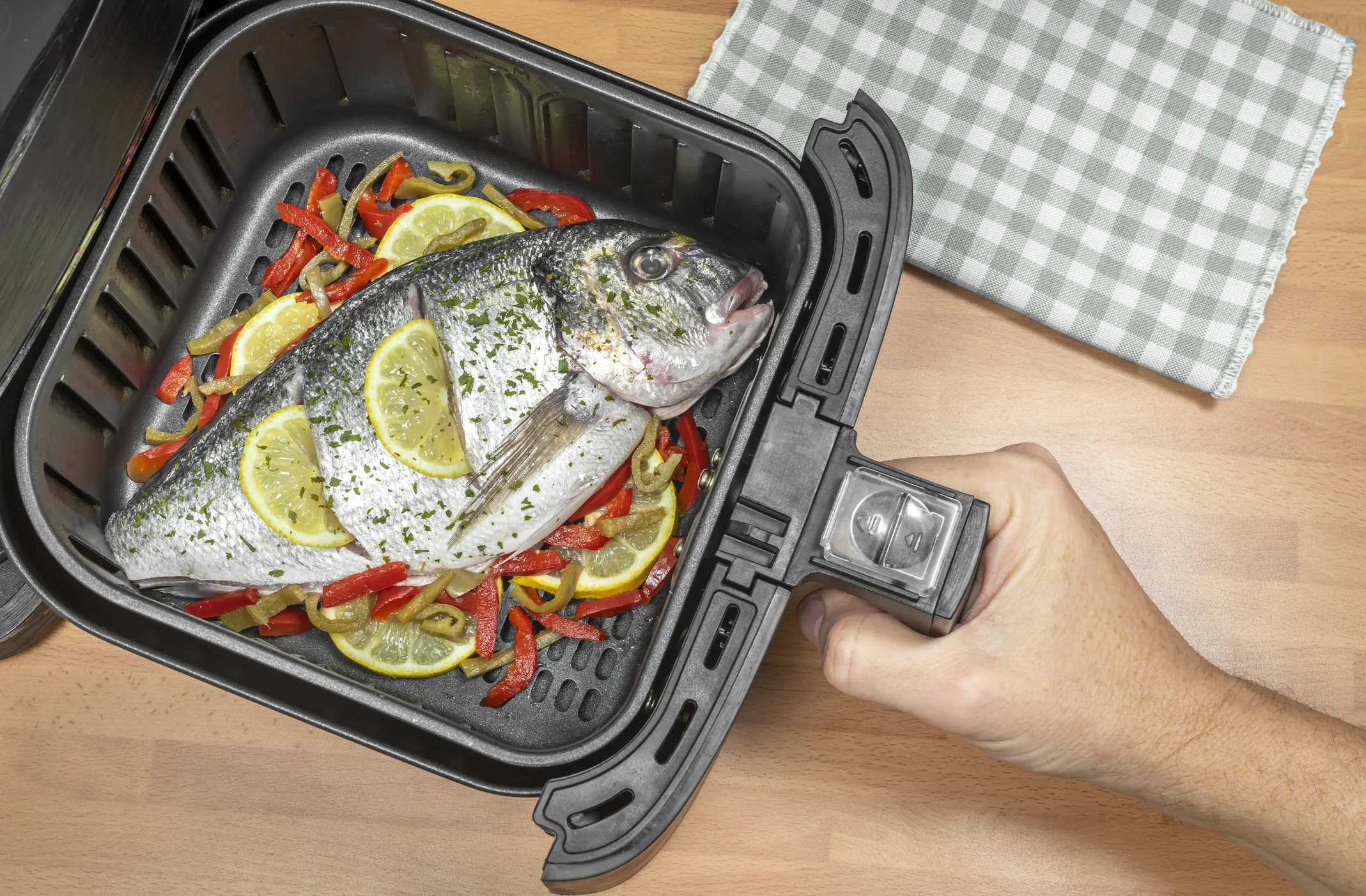Una dorada cocinándose en una freidora de aire.