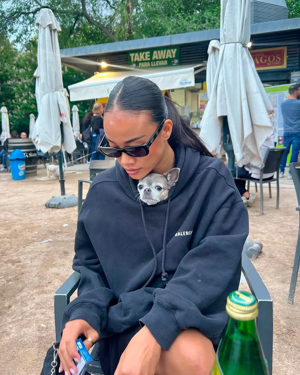 Nona Sobo con su perro dentro de su sudadera en la playa de Ibiza