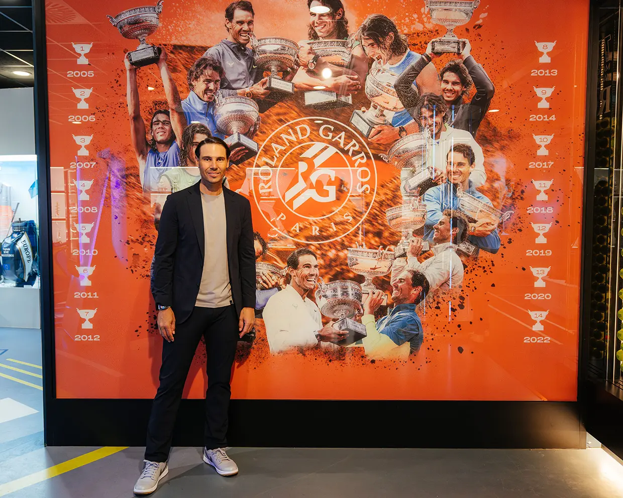 Rafa Nadal junto a una imagen que resume sus victorias en el torneo de Roland Garros