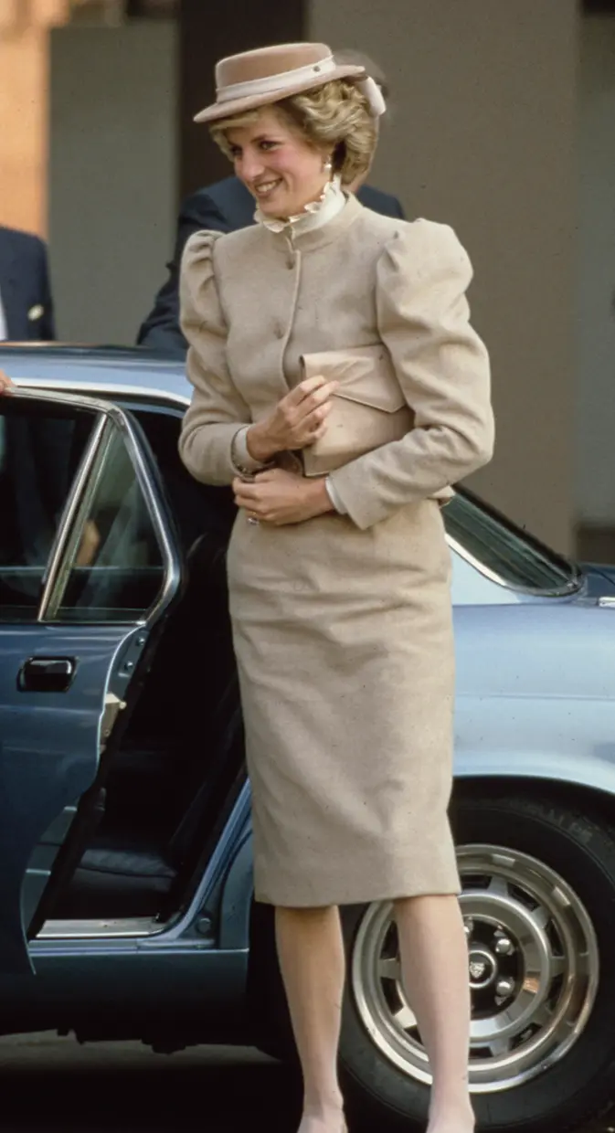 Lady Di con un vestido y un bolso beige.