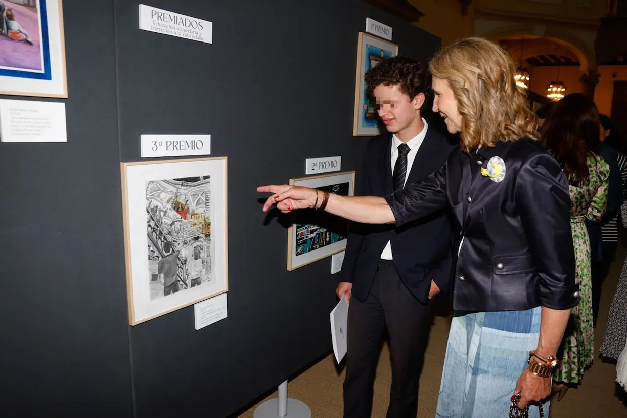 La infanta Elena comentando con un chico su pintura premiada