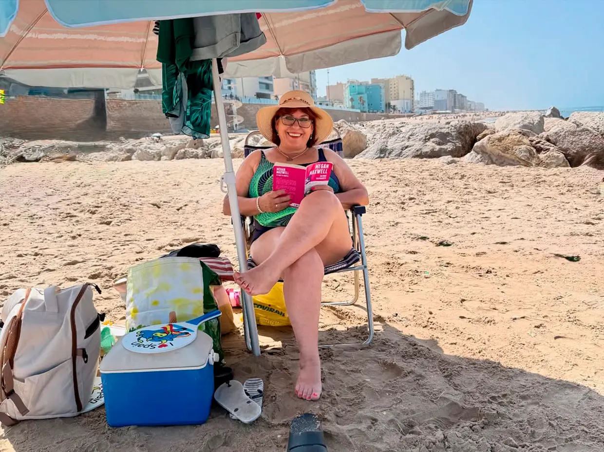 La madre de Roberto Leal, Mercedes Guillén, leyendo en la playa.
