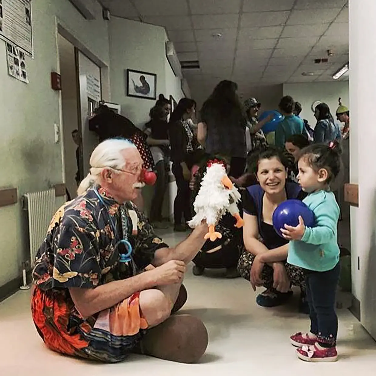 Patch Addams jugando con una niña en un hospital.