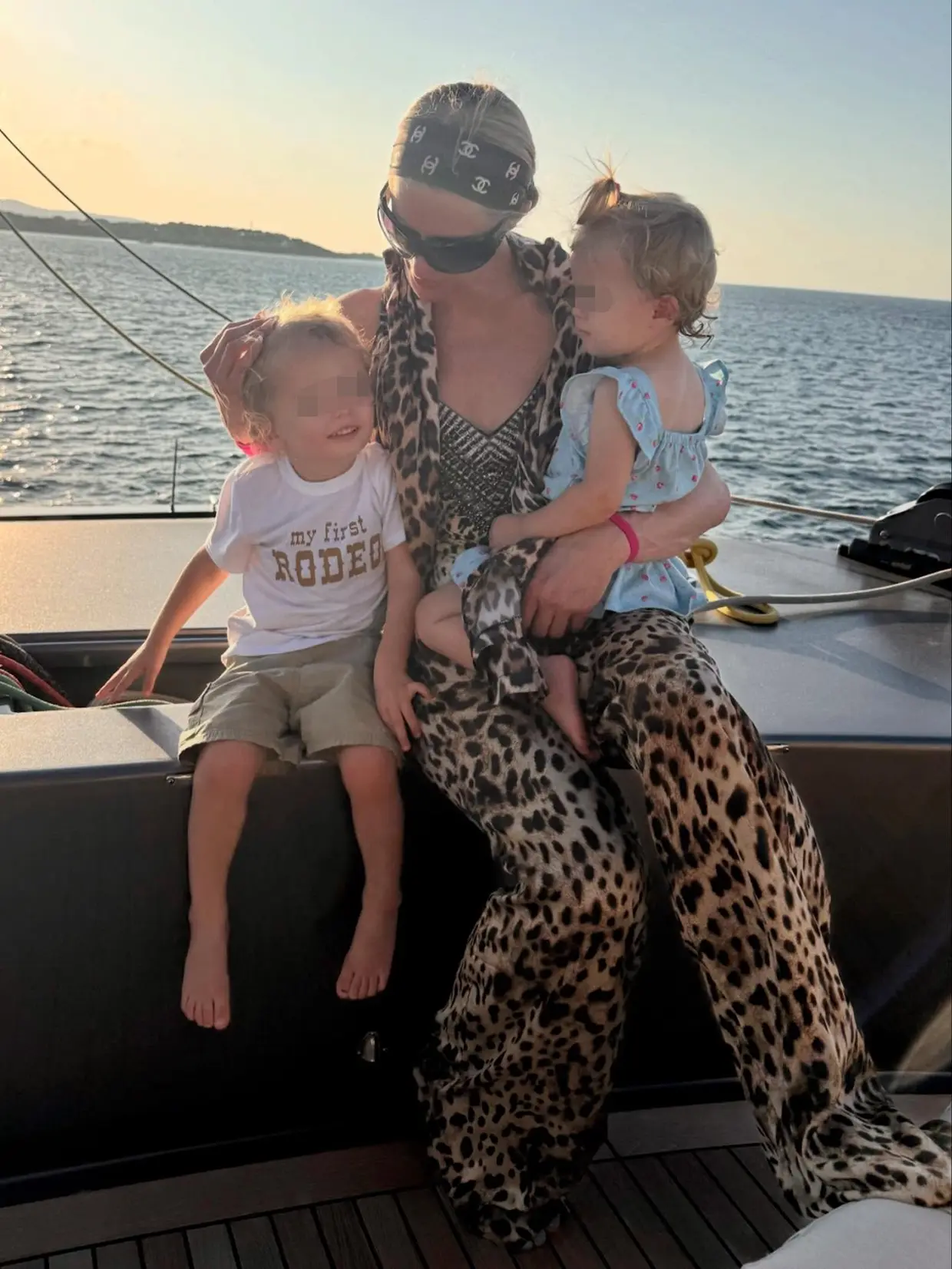Paris Hilton con sus hijos santada en la barandilla de un barco