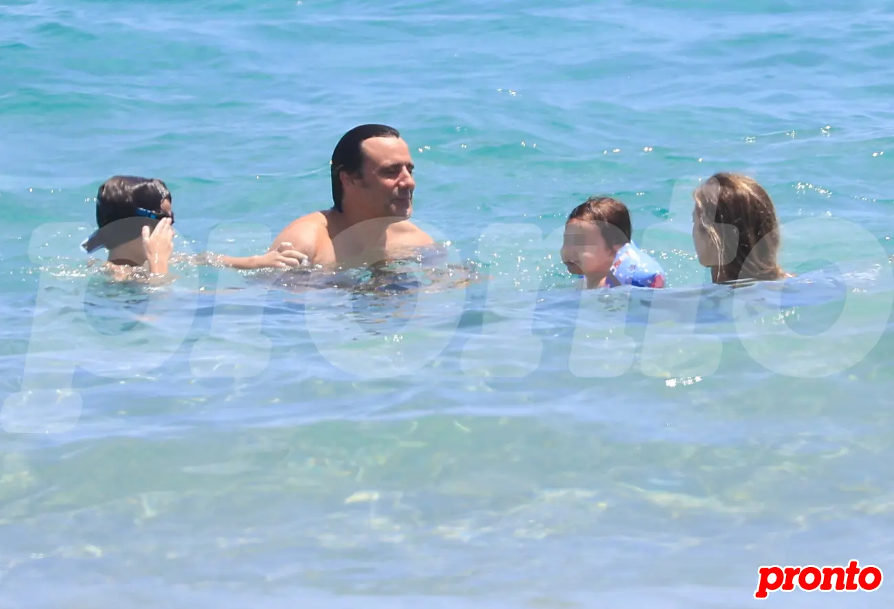 Ion Aramendi y María Amores bañándose en el mar en familia en la playa.