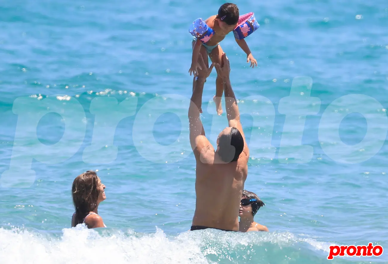 Ion Aramendi y María Amores jugando con su hija en el mar.