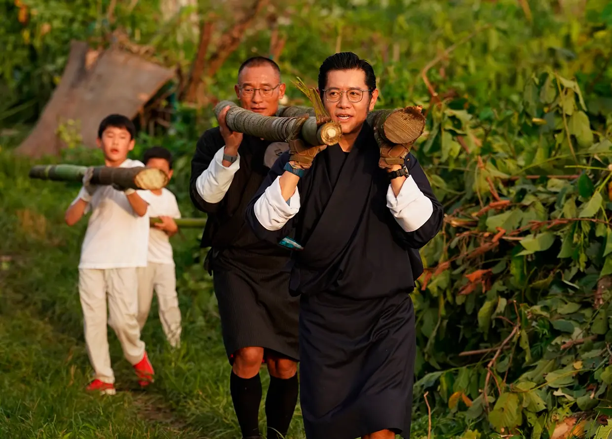 Familia real de Bután cargando troncos.