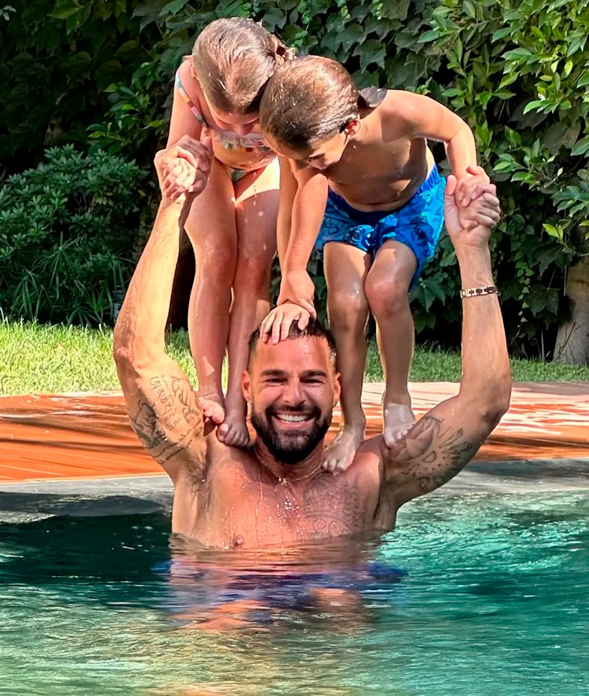 Ricky Martin con sus hijos en la piscina