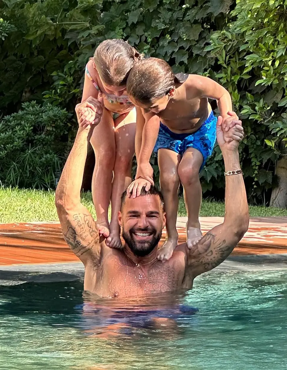 Ricky Martin con sus hijos en una piscina.