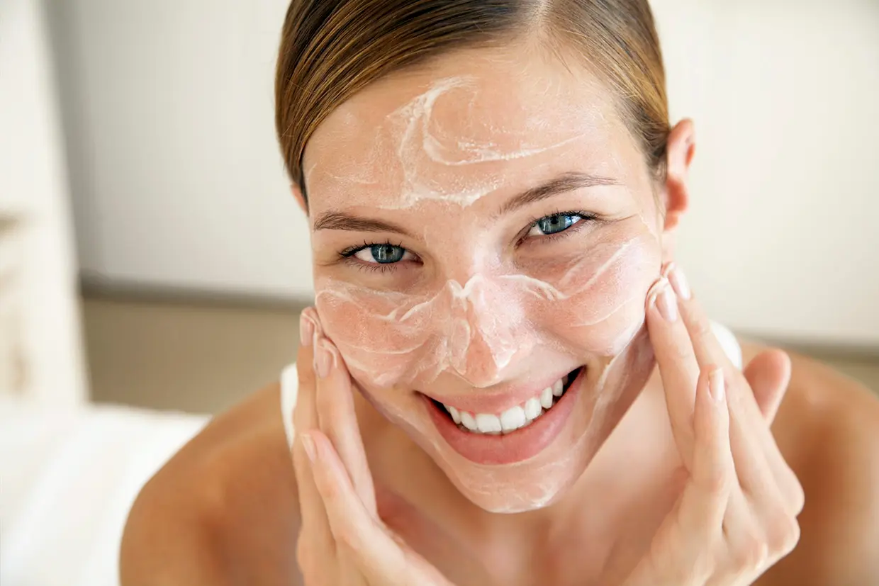 Mujer usando un limpiador facial