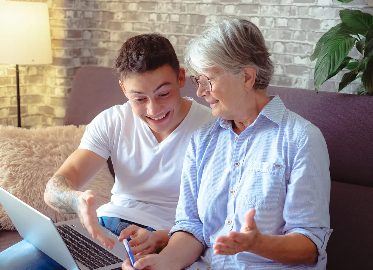 Nieto con su abuela mirando un ordenador portátil