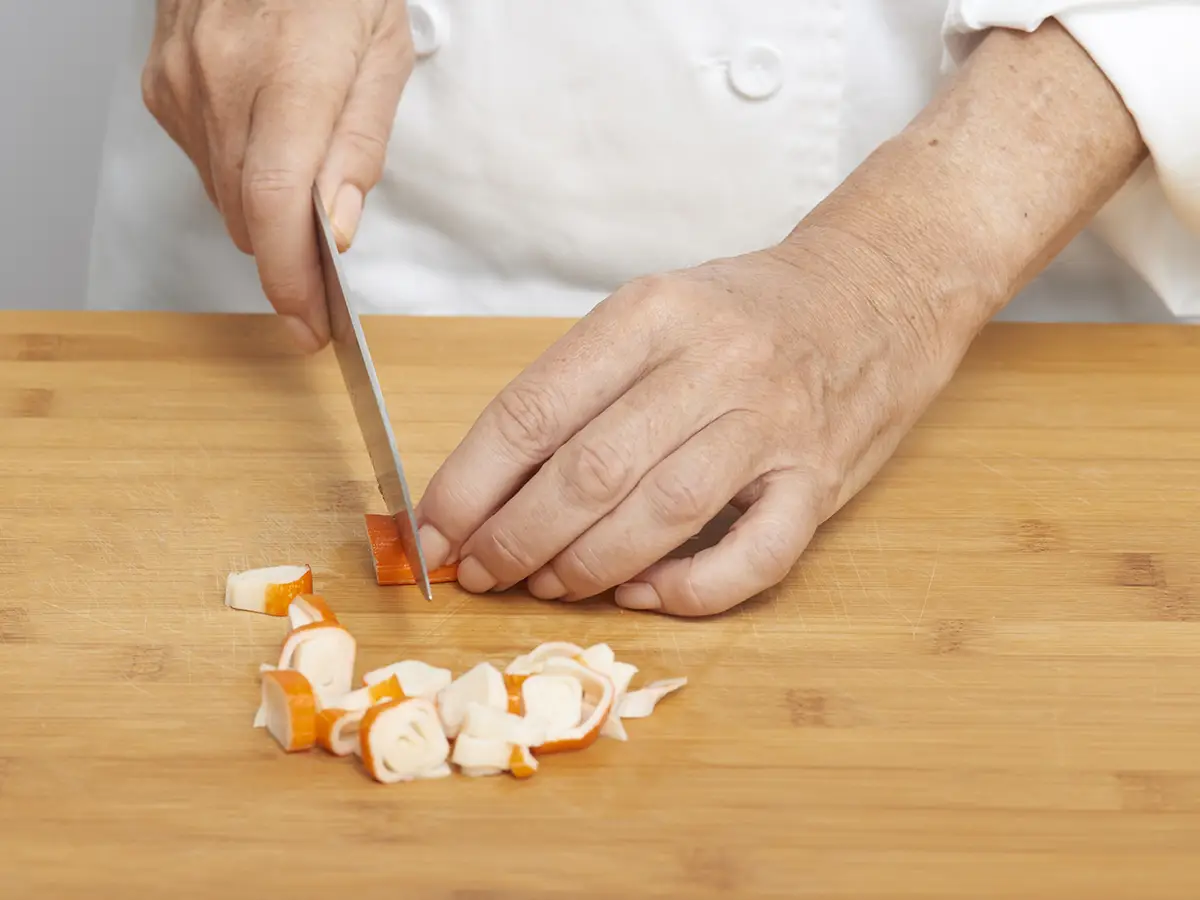 Corta el surimi en dados pequeños para la ensaladilla del relleno.
