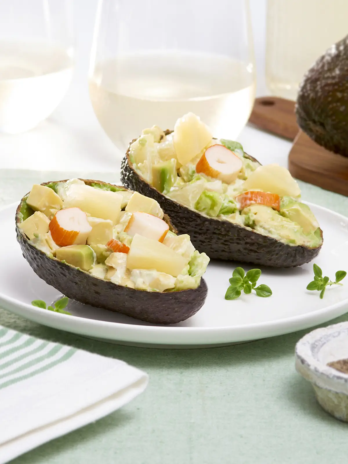 Mitades de aguacate rellenas de ensaladilla listas para servir en la mesa.