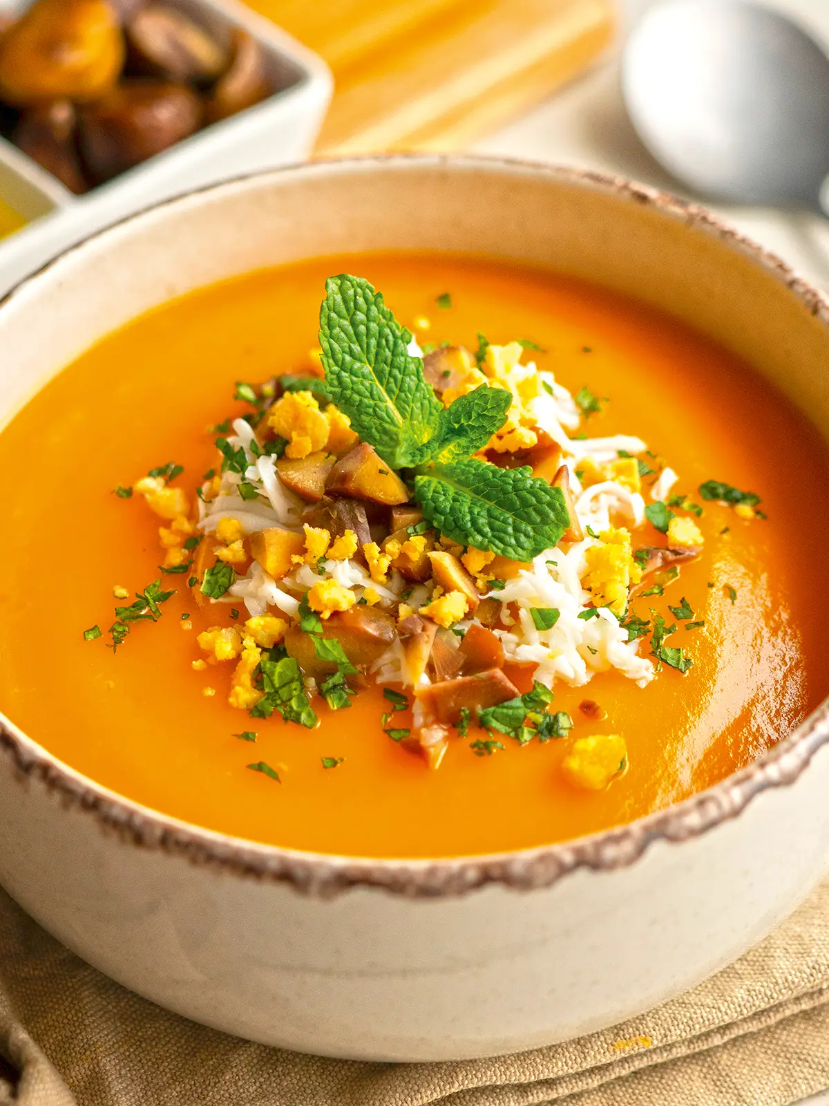 Crema de calabaza con castañas servida en bol con topping crujiente