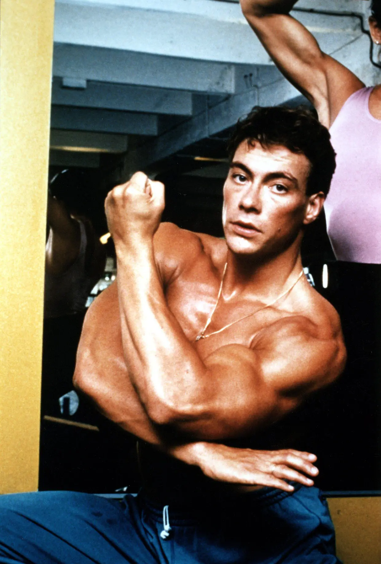 Jean Claude Van Damme de joven, marcando músculos.