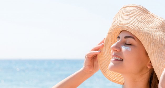 crema del sol mujer playa sombrero